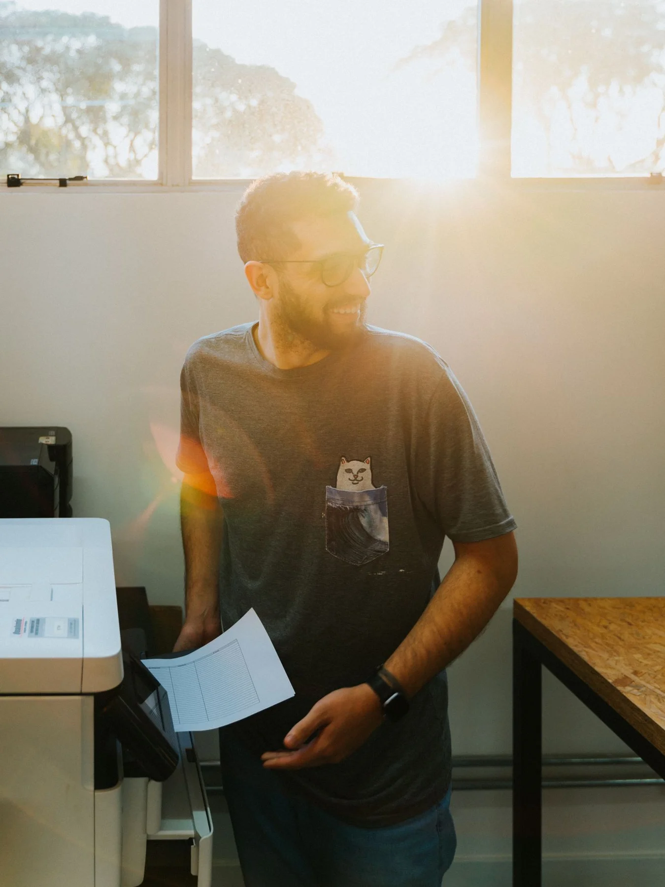 Eine Person nimmt Papier aus einem Drucker