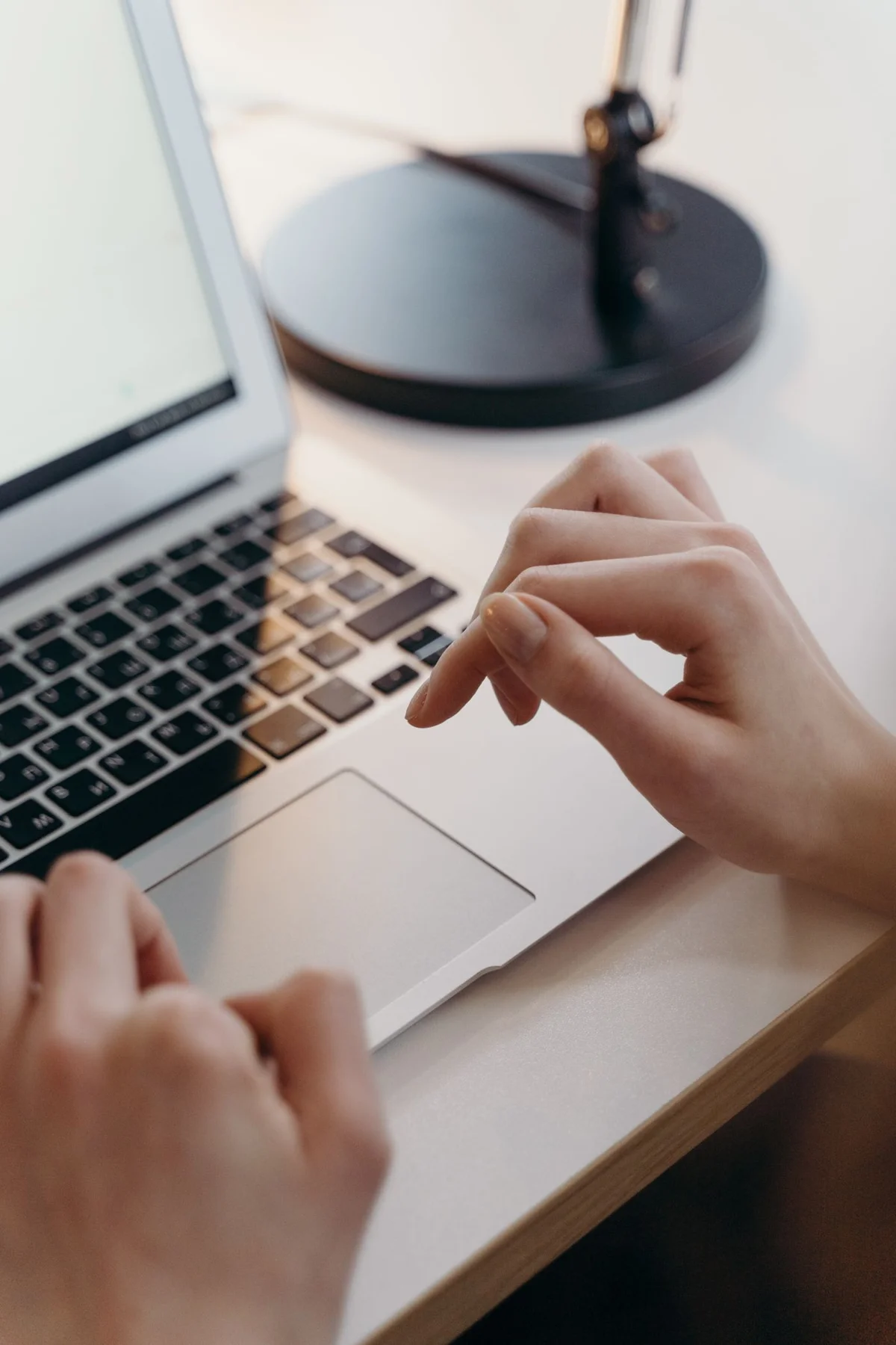 Hand am Touchpad eines Laptops