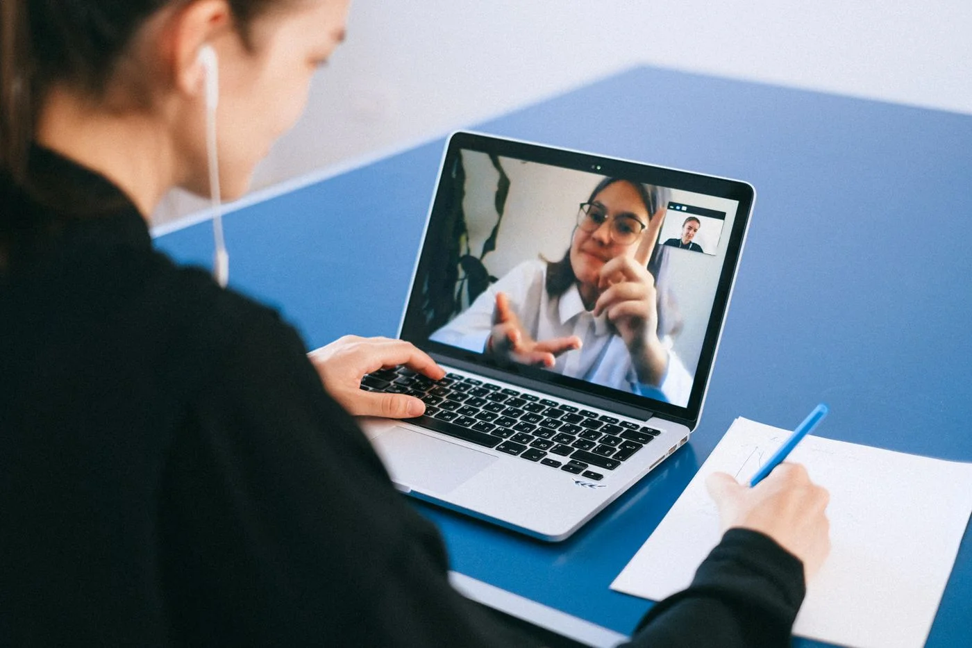 Videogespräch am Laptop mit Notizbuch